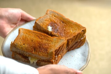 Kaya butter toast for breakfast. A classic Asian breakfast or snack, consist of toaster bread, sweet coconut milk and egg jam called kaya, and a slice of cold butter. Roti bakar sarikaya butter
