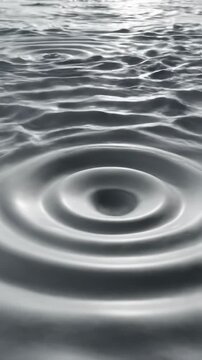 Gentle three dimensional ripples flow outward across an enormous smooth light gray field creating a sense of unending movement and potential seamless, smooth, growth