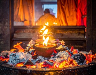 Traditional oil lamps burning brightly on hot coals during a sacred ceremony with a person