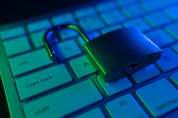 Cyber security lock resting on a glowing keyboard highlighting internet security concerns