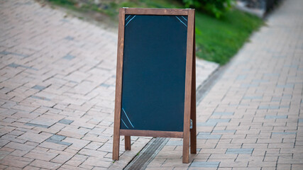 Blank chalkboard stand on sidewalk