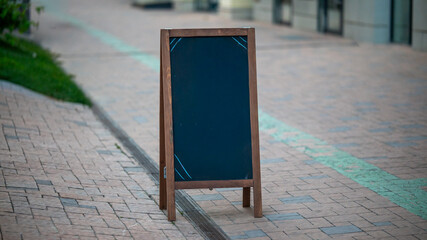 Blank chalkboard stand on sidewalk