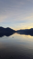 Perfect still water reflection of mountains and sky at sunset