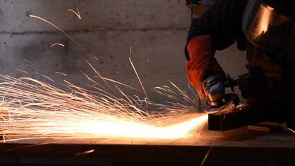 Angle grinder cutting steel with intense sparks in workshop