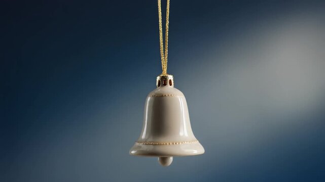 Ceramic bell ornament descending on gold thread