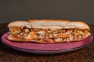 Long sandwiches with chicken breast, eggs, cabbage, cheese and dressing on plate