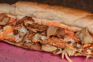 Long sandwiches with chicken breast, eggs, cabbage, cheese and dressing on plate