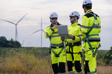 Engineers discuss project details at a wind farm during late afternoon