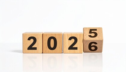 Wooden blocks transitioning from 2025 to 2026 on reflective surface with white background&mdash;symbolic New Year concept for planning, celebration, and reflection visuals.