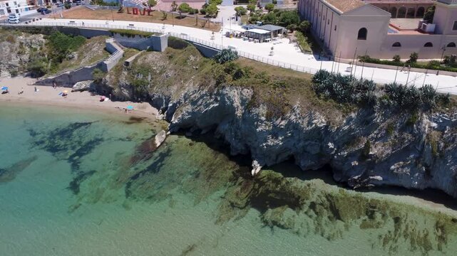 Beautiful Clear Waters and Sandy Beach Invite Relaxation and Fun Near the Cliffs on a Sunny Day. Terrasini, Sicily, Italy