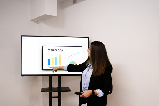 Businesswoman presenting financial results on screen in office