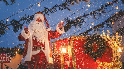 Santa Claus waves hello in a festive winter wonderland scene with snowfall.