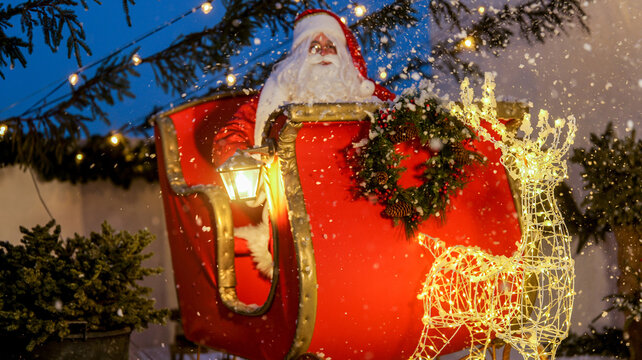 santa claus in his sleigh with a glowing reindeer and falling snow