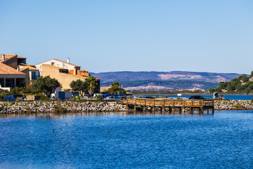 Fototapeta premium Village of Gruissan on the horizon from the opposite shore of the Gruissan lagoon