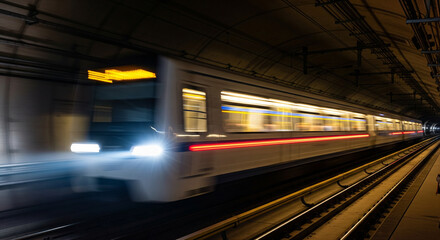Urban Transit Blur - Subway Train Speeding Through Dark Tunnel
A dynamic, long-exposure photograph capturing a modern subway or metro train rushing through a dark underground tunnel at high speed