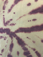 Abstract purple tie-dye pattern on fabric with soft organic shapes and blurred dye edges. Vibrant textured background ideal for textile design, boho style, crafts, and artistic decorative concepts.