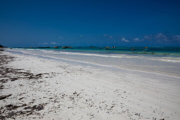 Beautiful white sand beach. Beach in Zanzibar. Sunny day. Blue sky. Colorful sea.
