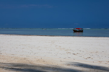 Beautiful white sand beach. Beach in Zanzibar. Sunny day. Blue sky. Colorful sea.