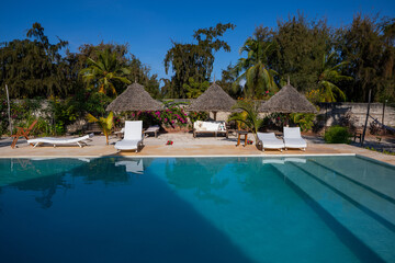Beautiful bungalows in Zanzibar. Resort with pool. Sunny day.