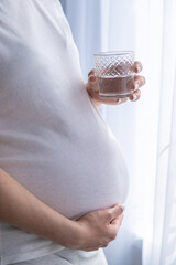 A pregnant woman drinks water. Selective focus.