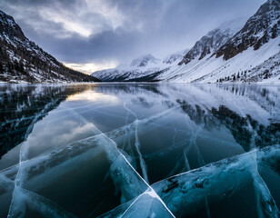 Snowy mountain lake with still reflections and misty cold alpine scenery