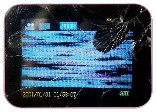 Close-up of a broken digital camera or handheld device screen displaying distorted static, glitch artifacts and a cracked glass surface.