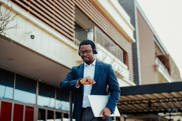 African american businessman checking time wearing headphones