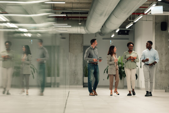 Diverse business team walking through modern office discussing work