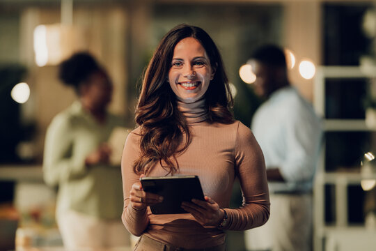Female professional smiling holding digital tablet in office - Powered by Adobe