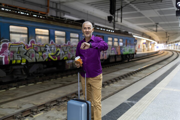 Man checking smartwatch on train station platform