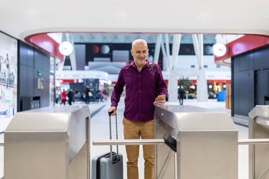 Man passing through turnstile using smartphone for access
