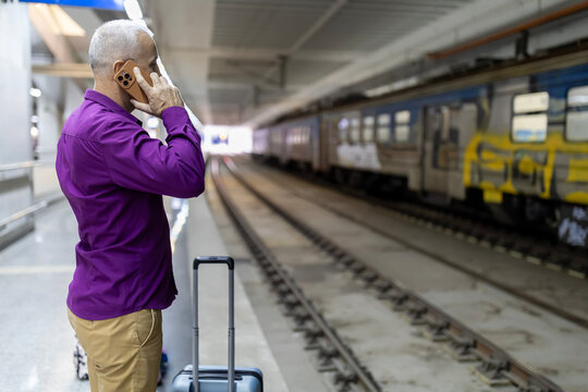 Traveler communicating on smartphone at train station platform