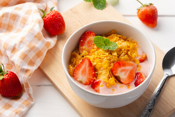 Cornflakes with fresh strawberries and yoghurt in white bowl.delicious healthy breakfast.