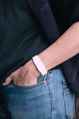 White access bracelet with a microchip. Contactless silicone key pass. Functional gadget RFID wristband on hand. 