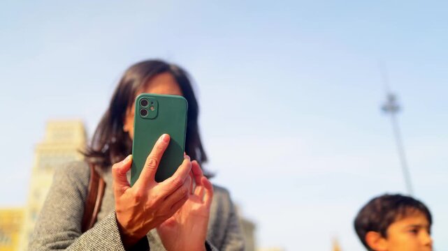 Traveler woman navigating barcelona with smartphone, enjoying urban exploration and cultural tourism at famous architectural landmark casa batll&oacute; on passeig de gr&agrave;cia