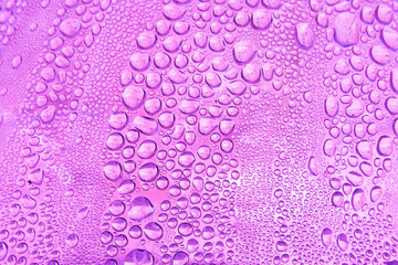 Abstract background featuring a macro view of water droplets on a violet surface, creating a natural pattern of moisture and condensation.