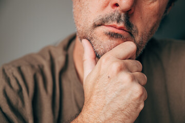 Closeup of thoughtful mature man touching chin, concept of contemplation and decision making....