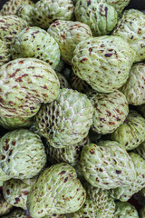 Organic custard apples arranged in a textured overhead pattern, creating a tropical background that highlights natural food aesthetics, healthy eating, and sustainable agriculture.
