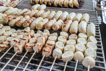 Grilled Nam Wa bananas on skewers, shown both sliced and whole, highlighting a healthy vegan Thai street snack with natural sweetness and authentic charcoal-grilled texture.