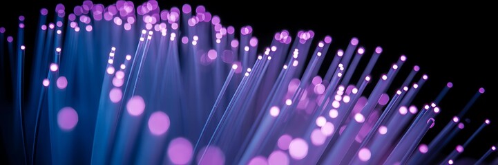 Fiber optics illuminated with purple and blue light against black background