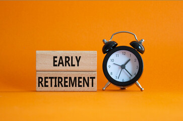 Early Retirement symbol. Wooden blocks with words Early Retirement. Beautiful orange background with alarm clock. Business and Early Retirement concept. Copy space.