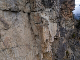Rugged Mountain Cliff Face Along a Peak in BC, Canada With Cloudy Sky