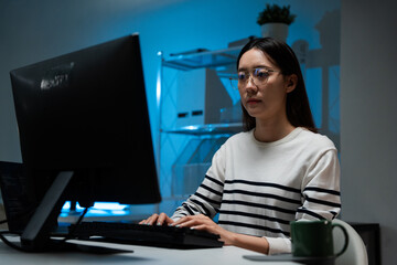 Focused Asian developer woman working at computer software development. IT engineer typing code, reviewing data. AI deep learning machine. Remote work at home. web design, programming application