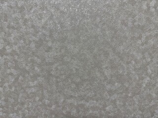 Abstract background with a light graysilver color and dense, fine, wavy texture. The non-uniform pattern creates a subtle frosted or shimmering metallic effect.