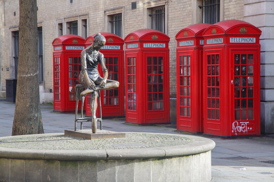 Young Dancer sculpture by Enzo Plazzotta and red telephone booths, Covent Garden, city of London, England