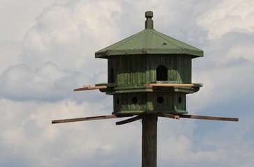 birdhouse
wooden birdhouse
bird feeder
bird house
nesting box
bird shelter
wooden structure
handmade birdhouse
rustic birdhouse
green birdhouse
sky
blue sky
outdoors
house in the sky