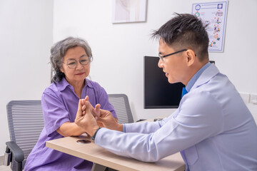 Fototapeta premium asian senior woman getting physical examine hand joints pain from orthopedic specialist doctor