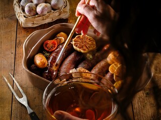 A cook prepares juicy pork sausages in a cozy kitchen, brushing them with garlic oil and surrounded by herbs. This dish captures the essence of traditional Romanian comfort food