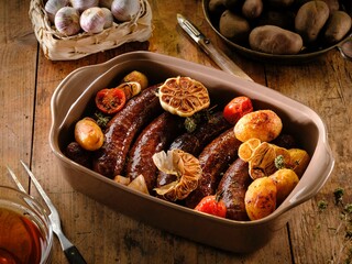 Savor the flavors of authentic Romanian cuisine with juicy pork sausages and golden potato wedges, seasoned with rosemary and roasted garlic for a delicious winter feast
