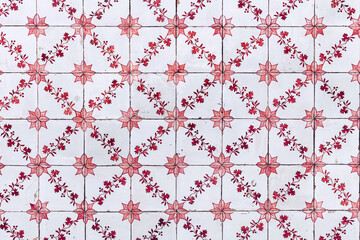 Typical old red and white azulejos at exterior wall of  residential building in Portugal.
